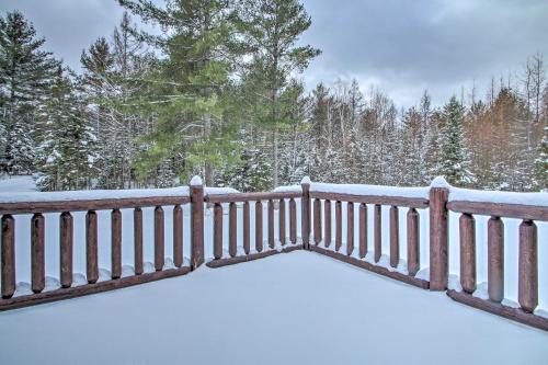 a fence covered in snow with trees in the background at Spacious Twin Mountain Vacation Rental on 5 Acres! in Twin Mountain