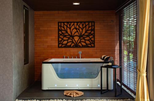 a bathroom with a large tub in a brick wall at Sita Beach Resort in Ko Lipe