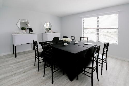a dining room with a black table and chairs at Vistalmar Beach Resort in Deerfield Beach