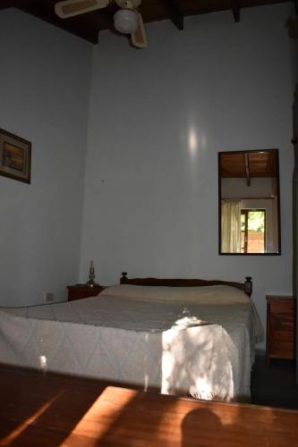 a bedroom with a bed with a mirror and a window at Dos ruedas in Mina Clavero