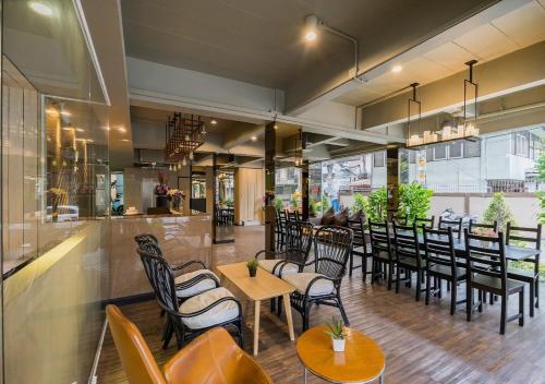 曼谷统奥广场酒店的一家有桌椅和酒吧的餐厅
