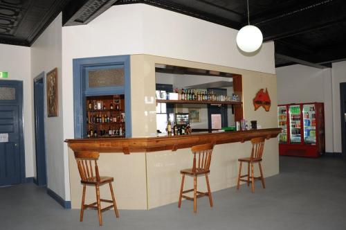 un bar en una habitación con 2 taburetes en Railway Bistro - Kandos, en Kandos