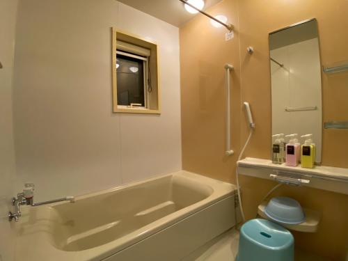 a bathroom with a tub and a toilet and a sink at LifeHouse IPPO in Otaru