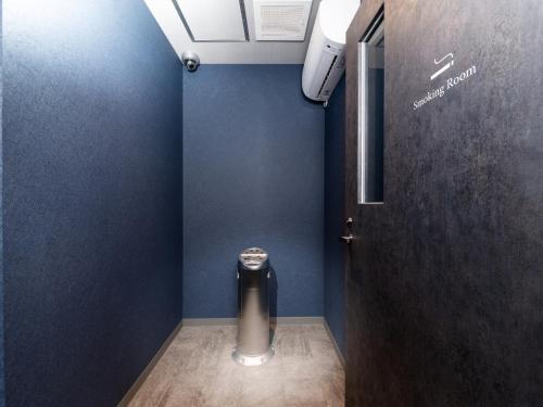 a bathroom with a trash can in a blue wall at MIMARU Tokyo Ginza East in Tokyo