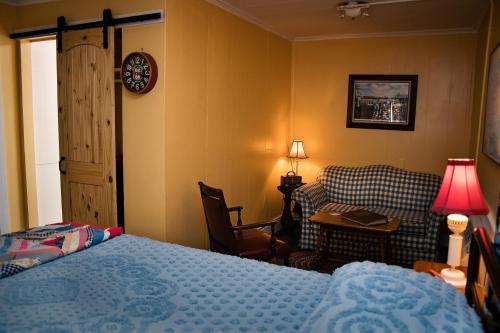 a bedroom with a bed and a chair and a table at Rockwood Motor Court in Springfield