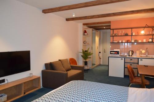 a room with a bed and a living room with a kitchen at Gudauri Atrium Redco in Gudauri