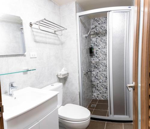 een badkamer met een douche, een toilet en een wastafel bij ioio in Tainan