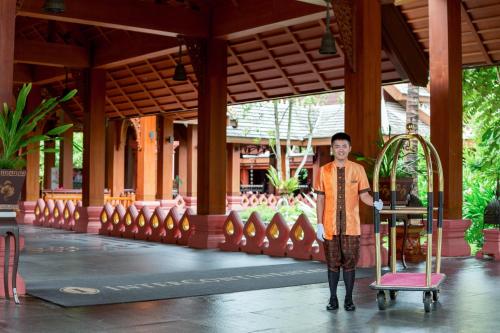 a man is standing in front of a building at InterContinental Xishuangbanna Resort by IHG in Jinghong