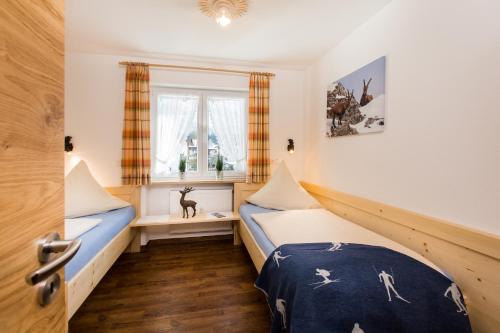 a bedroom with two beds and a window at Ferienwohnungen Anger in Oberstdorf