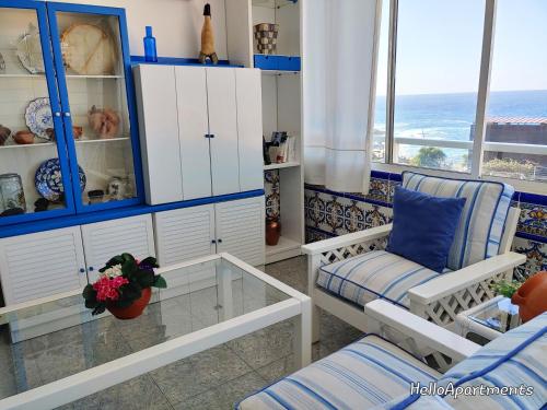 sala de estar con armarios blancos y mesa de cristal en Arena Terrace by HelloApartments, en Puerto de Santiago