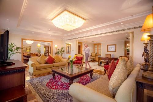 a man is standing in a living room at Corniche Hotel Abu Dhabi in Abu Dhabi