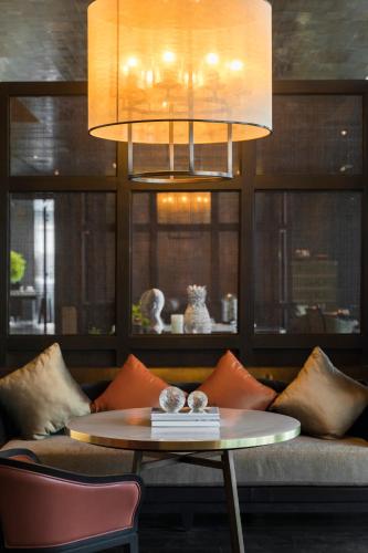 a living room with a table and a couch at Rosewood Phnom Penh in Phnom Penh