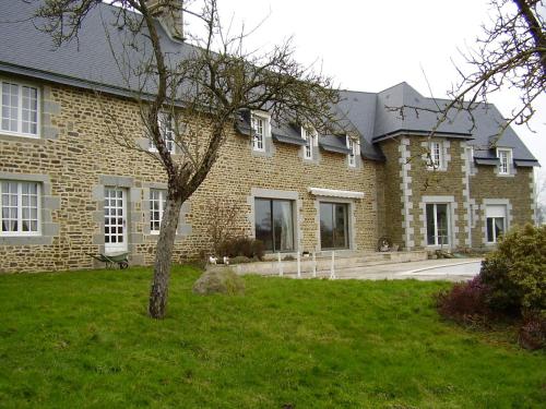 a large brick building with a tree in the yard at Le Relais Postal in Courson