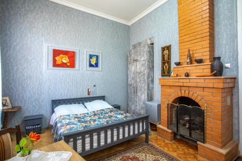 a bedroom with a bed and a brick fireplace at Gantiadi in Kutaisi