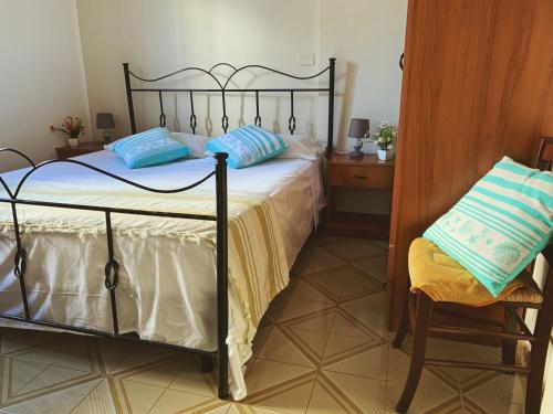 リド・マリーニにあるSoleMareSalento Ptのベッドルーム1室(青い枕と椅子付きのベッド1台付)