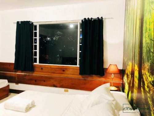 a bedroom with a window with a white bed at Casa Generosa in Baguio