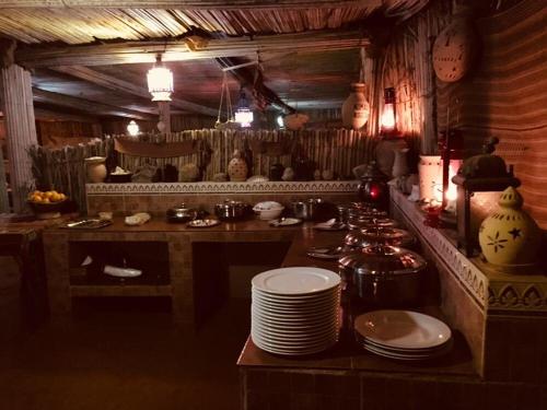 una cocina con encimera y una mesa con platos en Nomadic Desert Camp en Al Wāşil