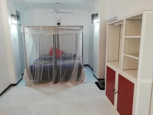 a bedroom with a bed with a mosquito net at Hotel Universal Beach in Hikkaduwa