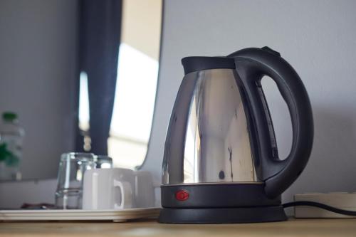 a black tea kettle sitting on top of a table at GO INN Chiang Mai University - CMU in Chiang Mai