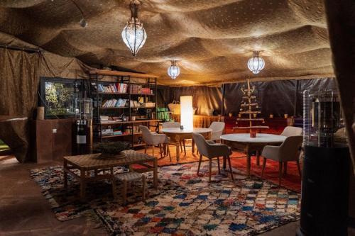 a room with a table and chairs and a book shelf at Les Jardins de Taja in Ourika