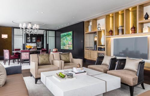 a living room filled with furniture and a tv at Rosewood Phnom Penh in Phnom Penh