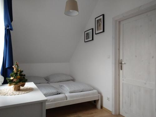 Pokój z łóżkiem ze stołem i drzwiami w obiekcie Domek w Białej - Bławatek w mieście Marcinowice