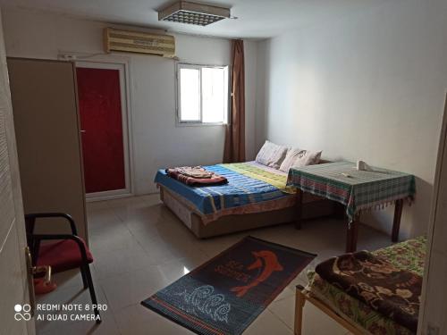 a room with two beds and a table and a window at Baskent Pansion in Lefkosa Turk