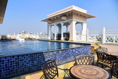 a swimming pool with chairs and a gazebo at Jhadol Vijay Vilas Near Lake Pichola in Udaipur