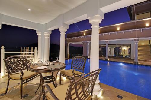 a patio with a table and chairs next to a swimming pool at Jhadol Vijay Vilas Near Lake Pichola in Udaipur