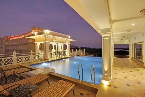 a hotel with a swimming pool on top of a building at Jhadol Vijay Vilas Near Lake Pichola in Udaipur