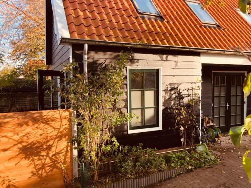 een klein huis met een oranje dak bij het zwaluwnest in Koudekerke