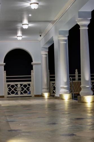 an empty room with white columns and a wooden floor at Jhadol Vijay Vilas Near Lake Pichola in Udaipur