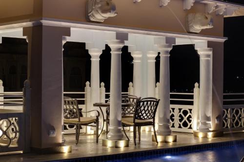 a patio with chairs and a table on a balcony at Jhadol Vijay Vilas Near Lake Pichola in Udaipur