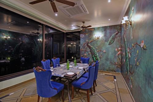 a dining room with a table and blue chairs at Jhadol Vijay Vilas Near Lake Pichola in Udaipur