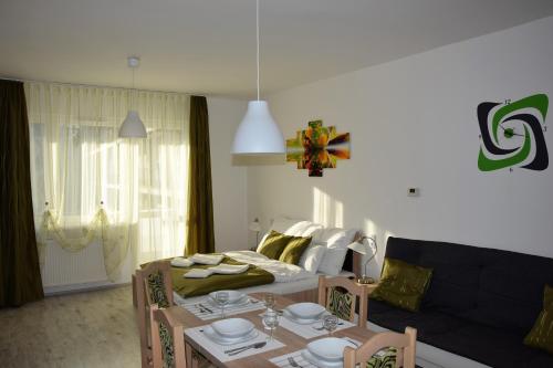 a living room with a table and a bed at Downtown Apartment Miskolc in Miskolc