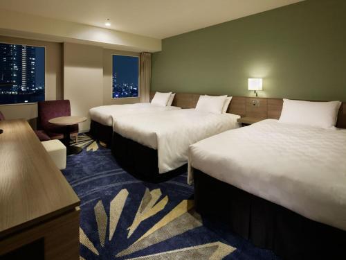 a hotel room with two beds and a table at Sunshine City Prince Hotel Ikebukuro Tokyo in Tokyo