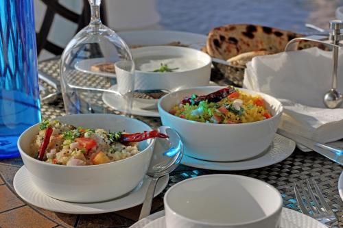 a table topped with bowls of food on a table at Jhadol Vijay Vilas Near Lake Pichola in Udaipur