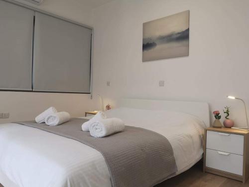 a bedroom with a bed with two towels on it at Nemesis in Larnaka