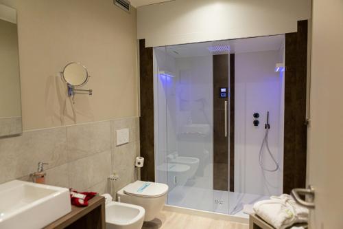 a bathroom with a shower and a toilet and a sink at Hotel Griso Collection in Malgrate