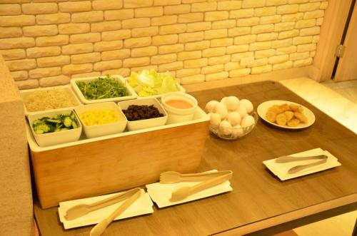 a wooden table with bowls of vegetables and other ingredients at Noble Hotel in Taipei