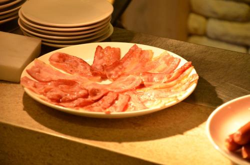 a plate of food with bacon on a table at Noble Hotel in Taipei