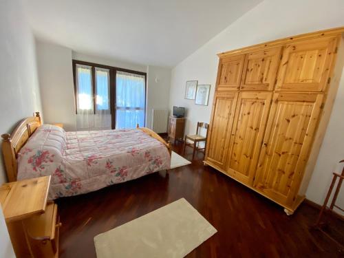 a bedroom with a bed and a wooden cabinet at Villa Moroni in Sondrio