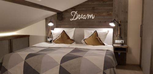 a bedroom with a large bed with a sign on the wall at Alpenchalet Vils Tirol in Vils