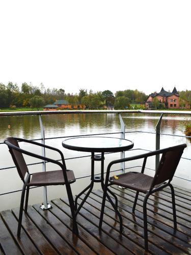 a table and two chairs and a table and chairs on a dock at Shepilska Relax Complex in Dovholuka