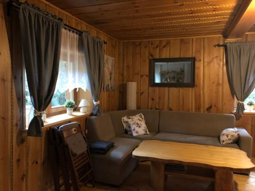 ein Wohnzimmer mit einem Sofa und einem Tisch in der Unterkunft Domek Malinka 13 in Wisła