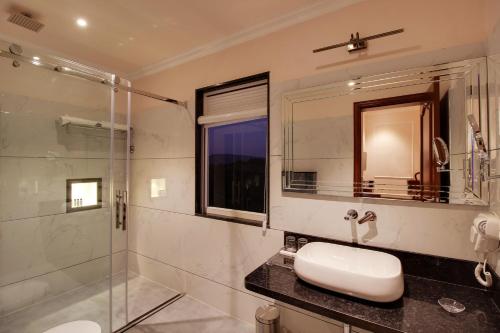 a bathroom with a sink and a glass shower at Jhadol Vijay Vilas Near Lake Pichola in Udaipur