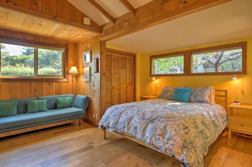 a bedroom with a bed and a couch and windows at Hillside Home with Deck and Views of Tomales Bay! in Inverness