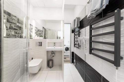 a white bathroom with a toilet and a sink at Bilkova Old Town Residence in Prague