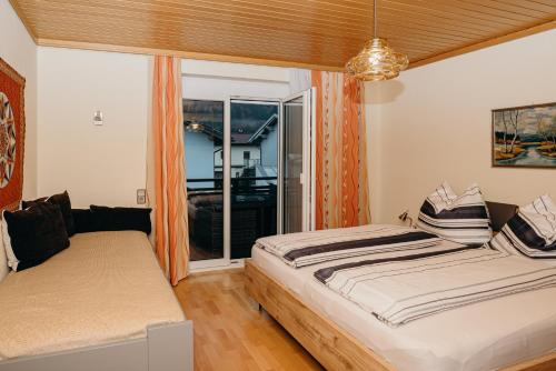 - une chambre avec 2 lits et une grande fenêtre dans l'établissement Ferienwohnung Hartlieb Goldeck Millstättersee, à Spittal an der Drau
