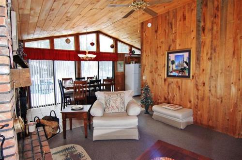 a living room with wood paneling and a living room with a couch and chairs at South Londonderry Home, Walk to Magic Mtn Ski Area in Londonderry